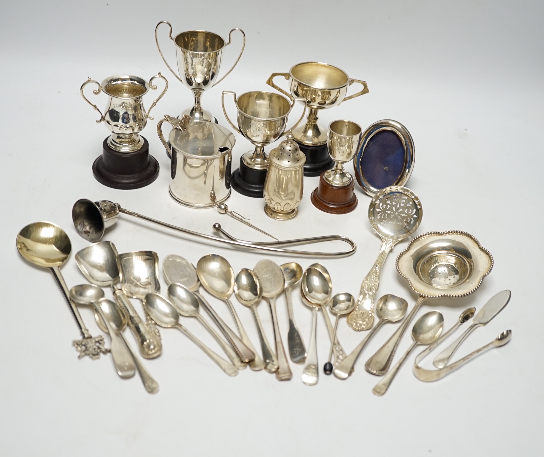 Sundry minor silver flatware including a Victorian Kings pattern sifter ladle, a silver mustard pot and pepperette, four small silver trophy cups and two other items.